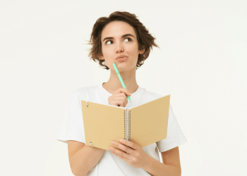 Jovem pensando com caderno e caneta em fundo claro.