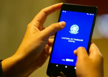 Pessoa acessando o aplicativo Carteira de Trabalho Digital pelo celular para consultar o Abono Salarial PIS/Pasep.