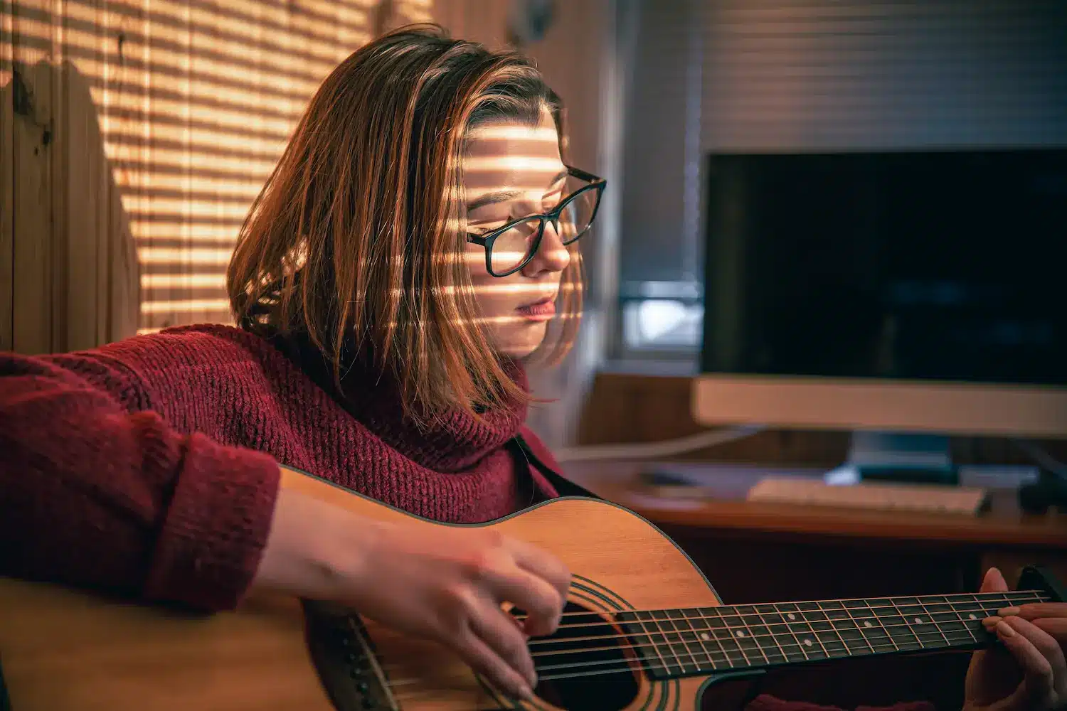 Pessoa praticando violão durante processo de aprendizagem e desenvolvimento de novas habilidades cognitivas.