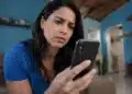 Mulher consulta celular em casa para verificar chamadas suspeitas e evitar ligações de telemarketing