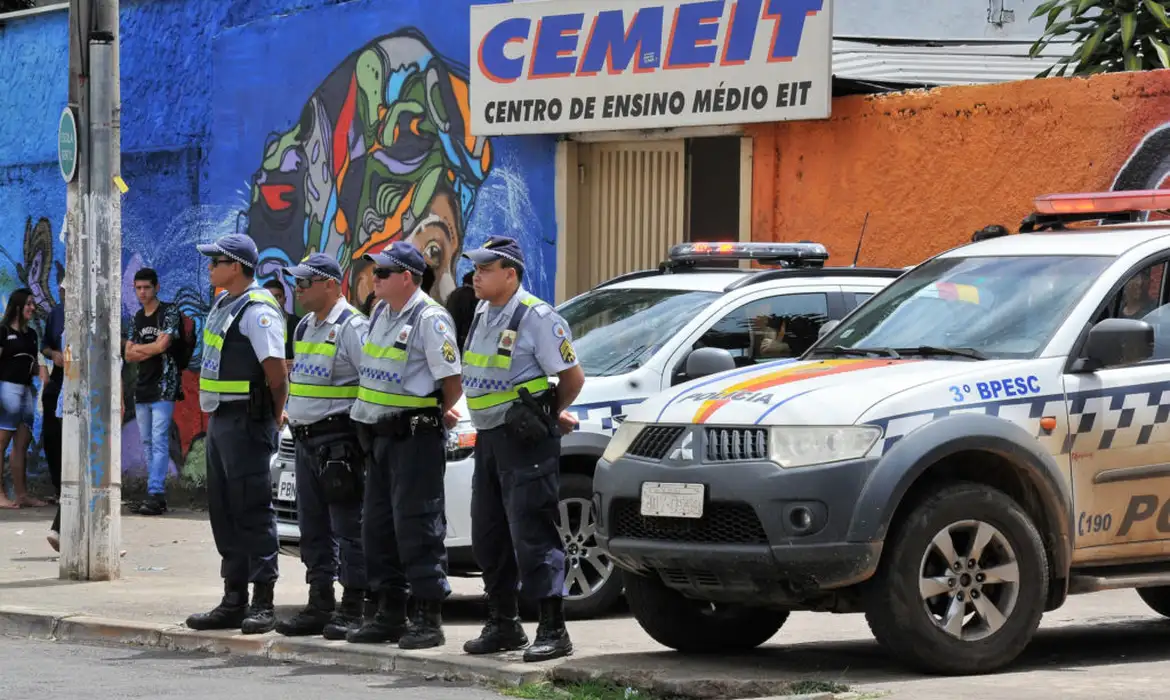 Policiais em frente a escola durante operação de segurança para garantir a continuidade das atividades escolares.