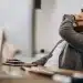 Homem em ambiente de escritório demonstrando cansaço e sobrecarga emocional após rotina intensa de trabalho e responsabilidades.