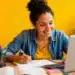 Jovem realiza estudos online com notebook e material didático, representando os cursos profissionalizantes gratuitos.