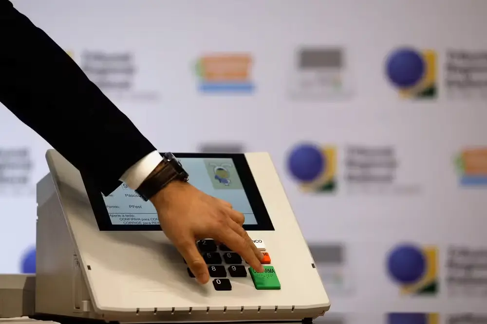 Urna eletrônica sendo utilizada em votação, ilustrando o calendário das Eleições de 2026 no Brasil.
