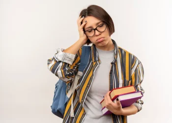 Estudante com livros e mochila demonstra dúvida sobre a escolha do curso.