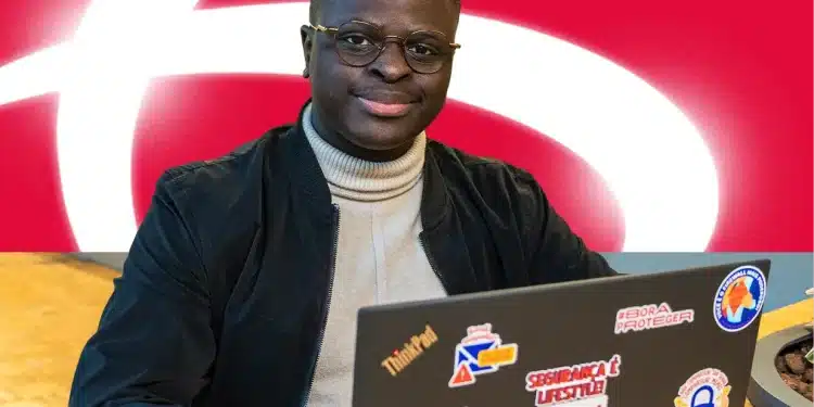 Jovem participante do Programa de Estágio Bradesco em frente ao computador, com logo do Bradesco ao fundo.