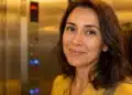 Mulher brasileira sorrindo dentro de um elevador residencial, representando o hábito de dar bom dia.
