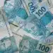 Notas de 100 reais simbolizando pagamentos do INSS em julho de 2026, com destaque para o teto de benefícios de R$ 8.475,55 e consulta via Meu INSS.