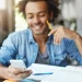 Estudante consulta simulados e exercícios do Enem pelo celular enquanto estuda.