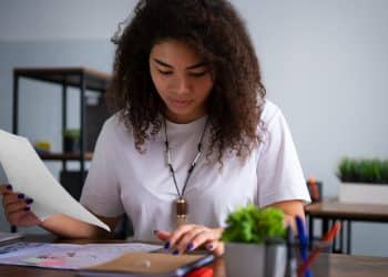Jovem revisando anotação em folha durante estudo com flashcards, aplicando técnicas de memorização para o Enem 2026