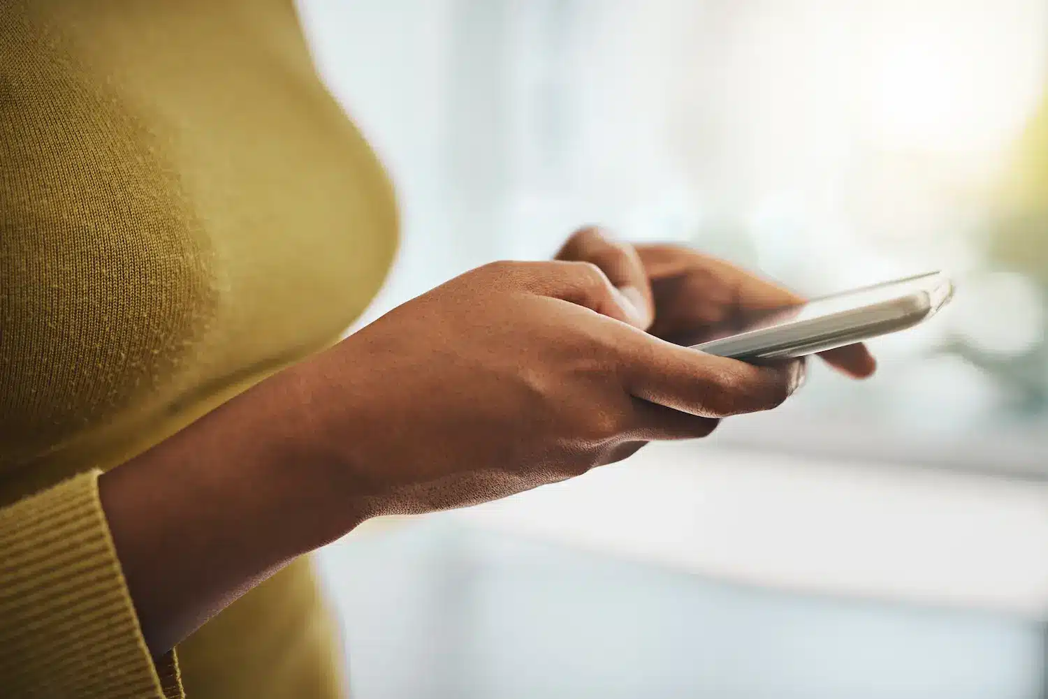 Pessoa utilizando celular para acessar canais digitais do Ministério do Trabalho.