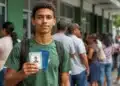Jovem segura documentos de identificação com uma fila de pessoas ao fundo, representando o mutirão para emissão da Carteira de Identidade Nacional (CIN), o novo RG.