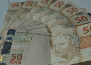 Cédulas de cinquenta reais dispostas em leque sobre superfície clara