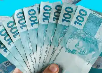 Notas de R$ 100 representando o pagamento, com valor de R$ 1.216 liberado em julho.