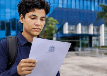 Pessoa segurando documento de nomeação após aprovação em concurso público.