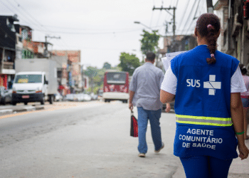 Agente Comunitário de Saúde do SUS realizando atendimento em área urbana durante processo seletivo em Minas Gerais.