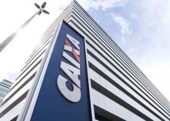 Fachada de um prédio da CAIXA Econômica Federal vista de baixo, com o logotipo azul em destaque, banco responsável pelo pagamento do Saque Calamidade do FGTS de até R$ 6.220