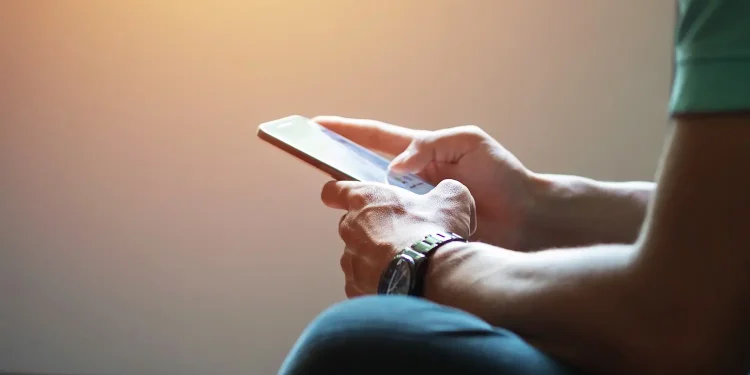 Pessoa utilizando o celular para acessar serviços digitais do Ministério do Trabalho.