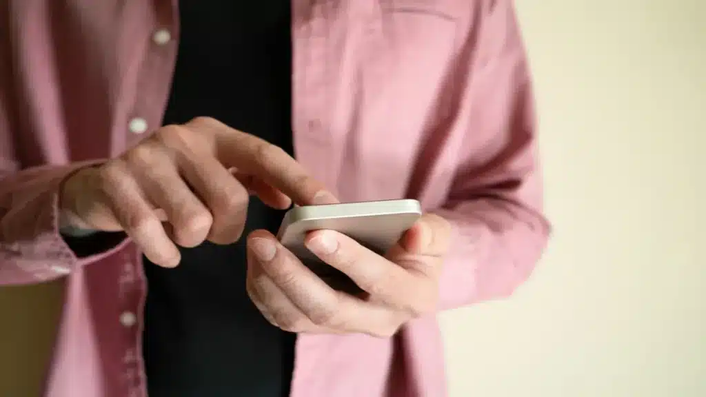 Pessoa utilizando celular para acessar o Não Me Perturbe e solicitar o bloqueio de chamadas de telemarketing