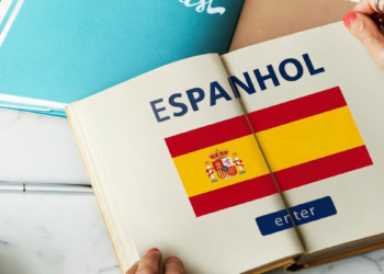 Livro aberto com bandeira da Espanha e texto "Espanhol".