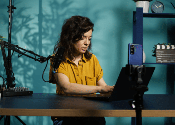 Criadora de conteúdo grava podcast com cenário moderno azul.