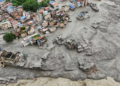 Casas destruídas por deslizamento de terra em área urbana durante enchente.