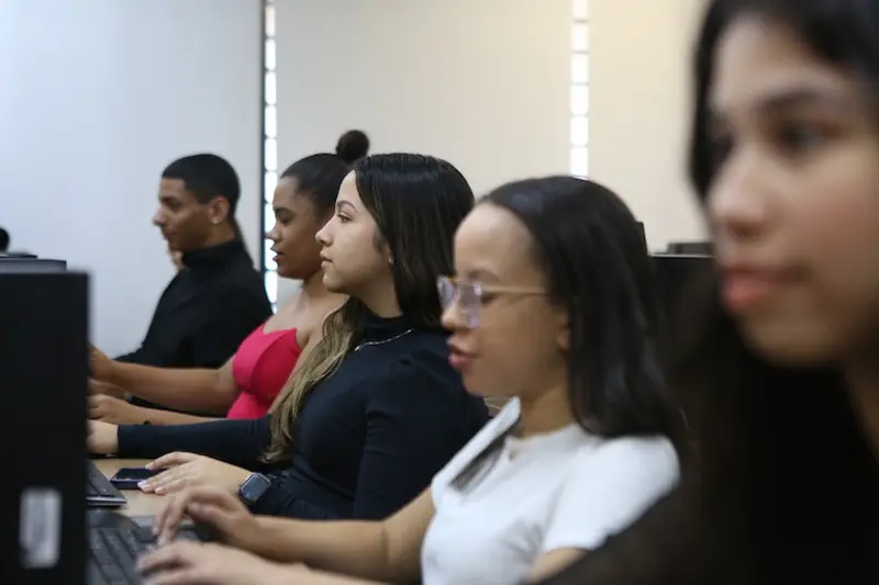 Estudante universitário acessando informações sobre a solicitação da Bolsa Permanência do ProUni na instituição de ensino.