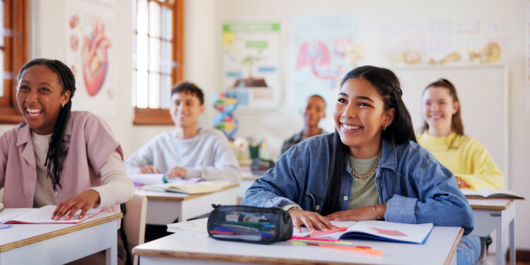 Estudantes atentos em aula de ciências em ambiente escolar descontraído.