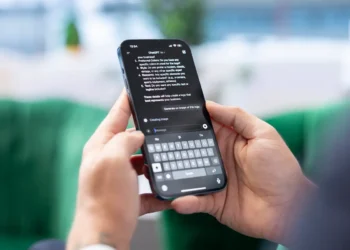 Mãos seguram celular com o ChatGPT aberto durante uma atividade de estudo.