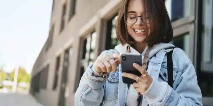 Estudante acessa aplicativo no celular, representando o uso do Clique Escola para consulta de informações educacionais.