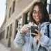 Estudante acessa aplicativo no celular, representando o uso do Clique Escola para consulta de informações educacionais.