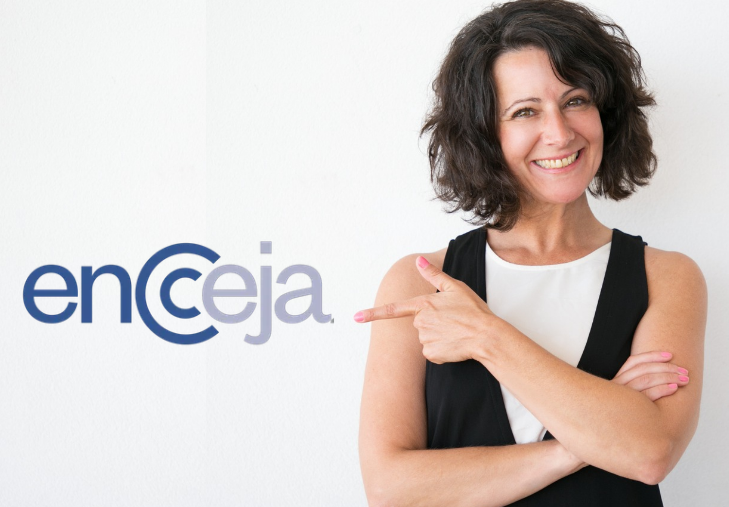 Mulher sorridente aponta para logotipo do Encceja 2026.