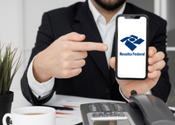 Homem de terno apontando para celular com a logo da Receita Federal.
