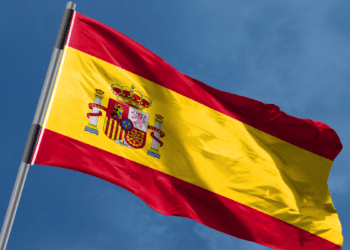 Bandeira da Espanha tremulando ao vento em dia ensolarado.