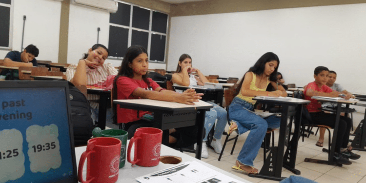 Aula de inglês descontraída com jovens em sala de aula.