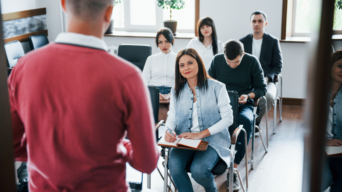 Grupo de jovens atentos em palestra interativa com instrutor.