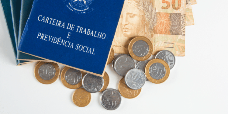 Carteira de Trabalho ao lado de reais representa vínculos e direitos.
