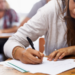 Estudante concentrada realizando prova em sala de aula.