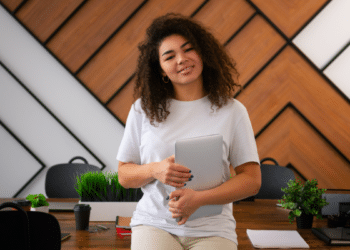 Jovem com tablet em escritório moderno.