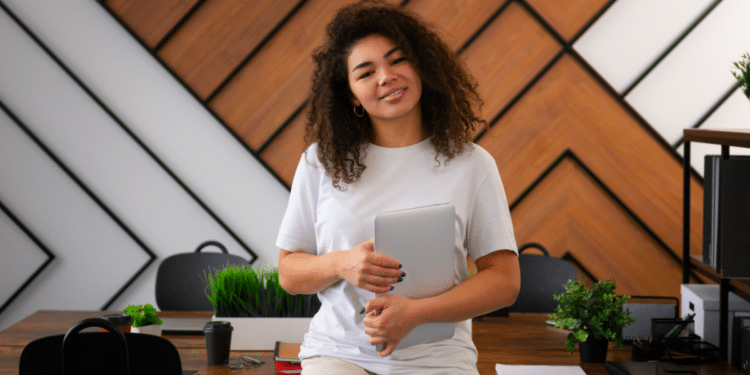 Jovem com tablet em escritório moderno.