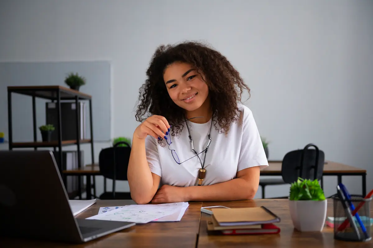 Jovem realizando atividades de estudo e preparação profissional em ambiente de trabalho, representando o contrato de aprendizagem.