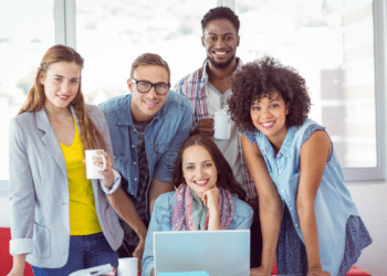 Jovens colegas sorrindo em ambiente moderno de escritório.
