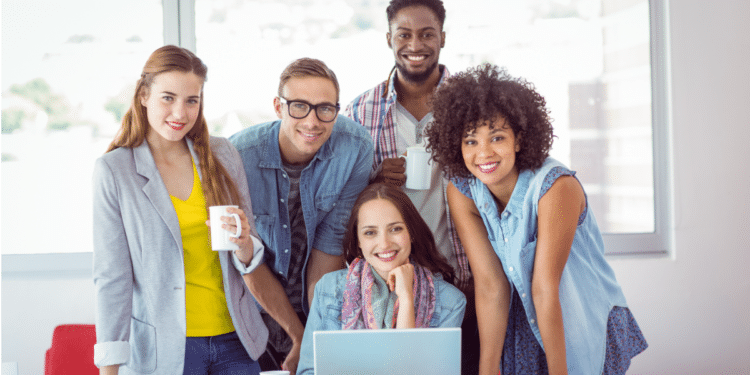 Jovens colegas sorrindo em ambiente moderno de escritório.