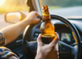 Motorista segurando cerveja enquanto dirige.