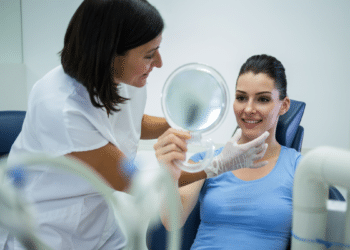 Consulta odontológica com paciente sorrindo após procedimento estético.