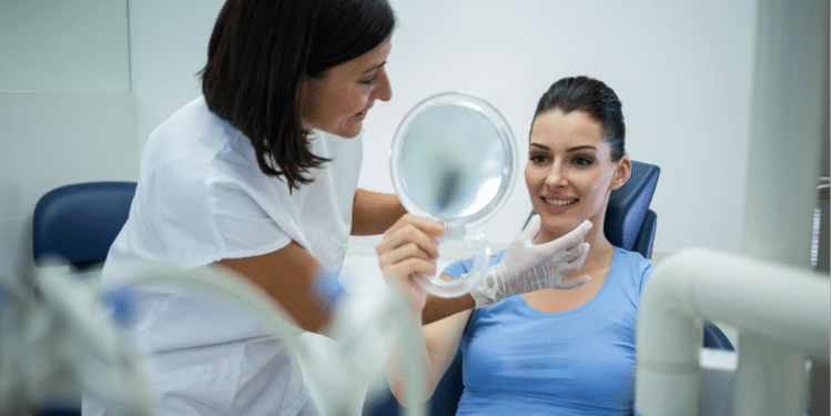 Consulta odontológica com paciente sorrindo após procedimento estético.