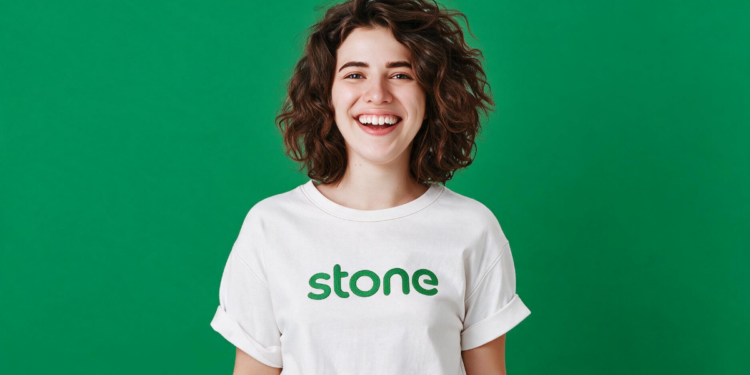 Jovem sorridente com camiseta da Stone em fundo verde.