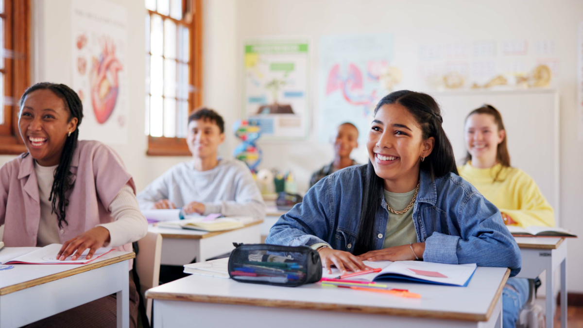 Estudantes em sala de aula interativa com clima de descontração.