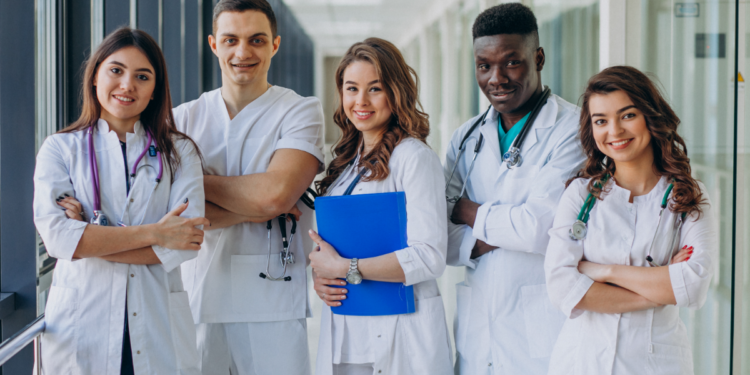 Residentes da saúde reunidos em corredor de hospital.