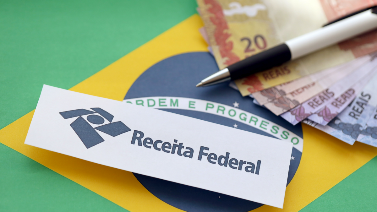 Receita Federal, notas de real e bandeira do Brasil em destaque.